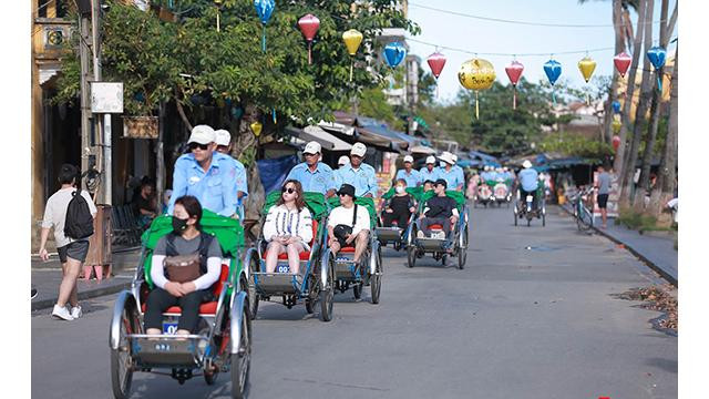 Chaque après-midi, on voit souvent des cyclos transportant des touristes étrangers sur le vieux quartier de Hôi An. Photo : Journal Tôquôc.