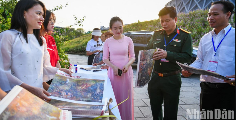 De nombreux encarts spéciaux contenant une copie de la peinture panoramique « Campagne de Diên Biên Phu » représentant plus de 4 500 personnages historiques, exposée au Musée historique de la Victoire de Diên Biên Phu ont été offerts aux habitants et aux touristes. Photo: NDEL