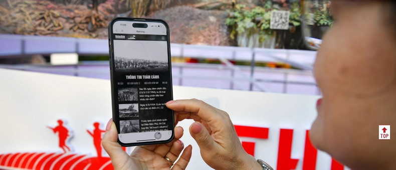 Un touriste profite de la page spéciale « Victoire de Dien Bien Phu » du journal Nhan Dan. Photo: NDEL