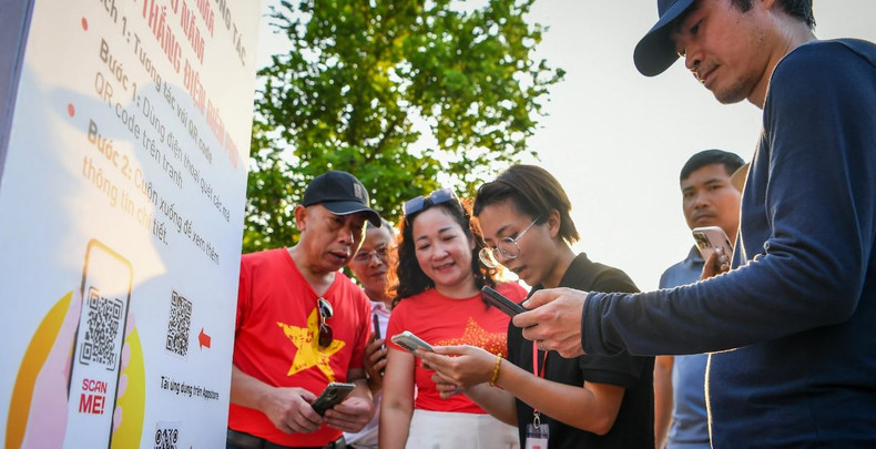 Les amateurs de technologie peuvent expérimenter l'interaction en utilisant leur téléphone pour scanner les codes QR sur les peintures ou en téléchargeant une application pour visualiser des images animées grâce à la technologie de réalité augmentée (AR). Photo: NDEL