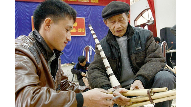 L'artisan Ma Khai So dans le district de Quan Ba apprend le jeune homme à jouer du khène des H'Mông. Photo : NDEL. L'artisan Ma Khai So dans le district de Quan Ba apprend le jeune homme à jouer du khène des H'Mông. Photo : NDEL.