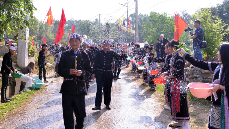 Sur le chemin du retour de l'eau, les familles du village jettent de l'eau sur les gens du groupe chargé de la cérémonie dans le but de prier pour la bonne chance pour toute l'année. Photo : nhandan.vn