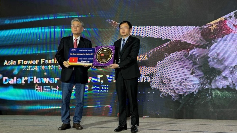 Le président du Comité populaire de la ville de Dà Lat, Dang Quang Tu (à droite) reçoit un logo honorant Dà Lat en tant que ville festive d'Asie, de la part de l'Association des festivals et événements internationaux pour la région d’Asie. Photo: doanhnghiepvn.vn