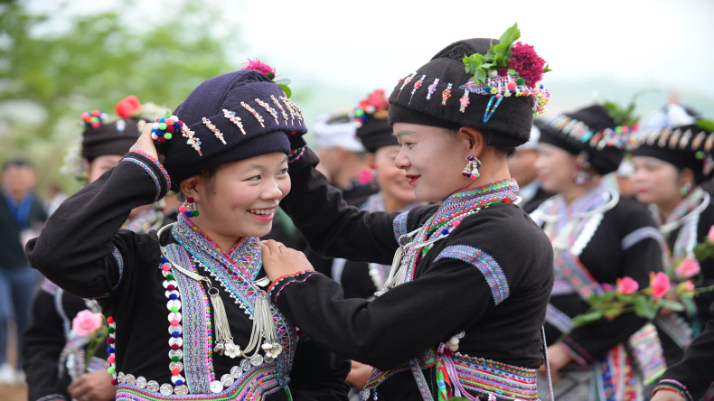 Les femmes s’habillent des foulards et des jupes dans la joie de la fête. Photo : nhandan.vn