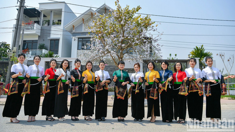 Des filles vêtues du costume du groupe ethnique Thái et des fleurs de bauhinie. Photo: Nhandan.vn Des filles vêtues du costume du groupe ethnique Thái et des fleurs de bauhinie. Photo: Nhandan.vn