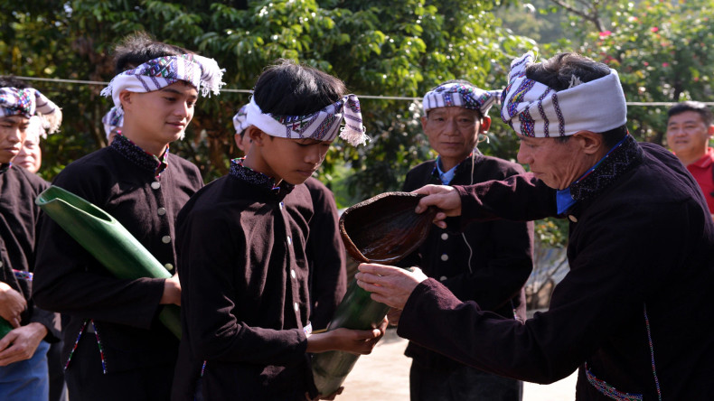 Ensuite, les jeunes hommes apportent des tuyaux de bambou pour demander de l'eau au propriétaire. Photo : nhandan.vn