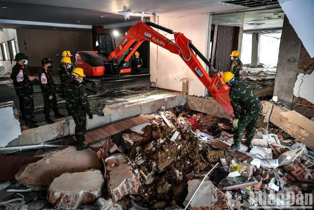 Des engins de terrassement ont été déployés sur le site pour faciliter la recherche dans les zones difficiles d’accès. Photo : nhandan.vn