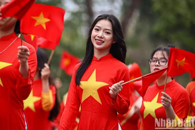 Les jeunes femmes vêtues d’ao dài aux couleurs du drapeau national. Photo : nhandan.vn
