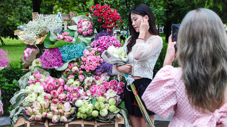 Des jeunes prennent des photos devant les vélos chargés de fleurs devant le parc de Lan Be. Photo: daidoanket Des jeunes prennent des photos devant les vélos chargés de fleurs devant le parc de Lan Be. Photo: daidoanket