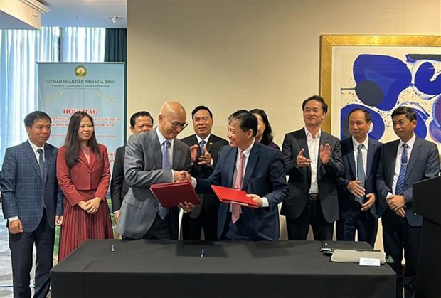 Le président du Comité populaire de la province de Hoa Binh, Bui Van Khanh, et le président de l'Association des entreprises vietnamiennes au Royaume-Uni, Paul Hoang, signent un document de coopération. Photo : VNA