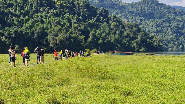 Un groupe de touristes a traversé la pelouse jusqu'au quai, commençant leur voyage pour visiter le lac de Ba Bê. Photo: daidoanket.vn Un groupe de touristes a traversé la pelouse jusqu'au quai, commençant leur voyage pour visiter le lac de Ba Bê. Photo: daidoanket.vn