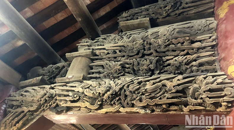 Les motifs sculptés sur la structure en bois de la maison communale. Photo : nhandan.vn Les motifs sculptés sur la structure en bois de la maison communale. Photo : nhandan.vn