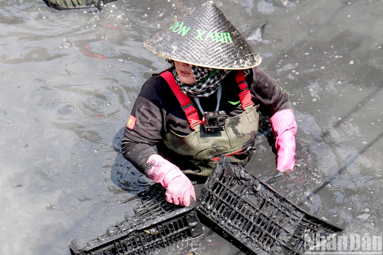 De nombreux jeunes de la commune de Phuoc Kiên, district de Nhà Bè, en collaboration avec le groupe Green Saigon et l’Association des amoureux des déchets, ont récemment dragué la coulée et amélioré le paysage du pont de Rach Chua Lon dans la commune de Phuoc Kiên. Photo : NDEL. De nombreux jeunes de la commune de Phuoc Kiên, district de Nhà Bè, en collaboration avec le groupe Green Saigon et l’Association des amoureux des déchets, ont récemment dragué la coulée et amélioré le paysage du pont de Rach Chua Lon dans la commune de Phuoc Kiên. Photo : NDEL.