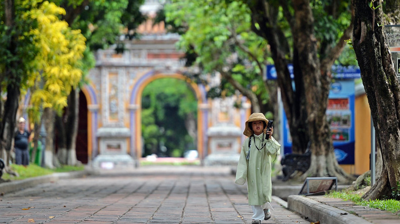 Une petite fille vêtue de l’ancien costume a suivi sa mère dans l'enceinte du Dai Nôi de Huê, en écoutant attentivement la présentation automatique via le dispositif du service touristique. Photo : nhandan.vn Une petite fille vêtue de l’ancien costume a suivi sa mère dans l'enceinte du Dai Nôi de Huê, en écoutant attentivement la présentation automatique via le dispositif du service touristique. Photo : nhandan.vn