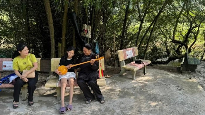 Un jeune touriste se renseigne sur le « dàn tinh », un instrument traditionnel de musique, à un point de repos près des chutes de Ban Giôc. Photo : VOV. Un jeune touriste se renseigne sur le « dàn tinh », un instrument traditionnel de musique, à un point de repos près des chutes de Ban Giôc. Photo : VOV.