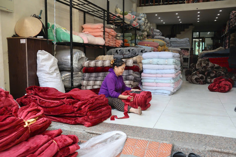 L'amballage de produits de couettes dans le village artisanal de Trat Câu, commune de Tiên Phong, district de Thuong Tin. Photo : hanoimoi.vn L'amballage de produits de couettes dans le village artisanal de Trat Câu, commune de Tiên Phong, district de Thuong Tin. Photo : hanoimoi.vn