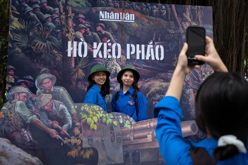 La zone de prise de photo sur le thème « Soldats vietnamiens tirant le canon sur le champ de bataille » attire de nombreux étudiants. Photo : nhandan.vn La zone de prise de photo sur le thème « Soldats vietnamiens tirant le canon sur le champ de bataille » attire de nombreux étudiants. Photo : nhandan.vn