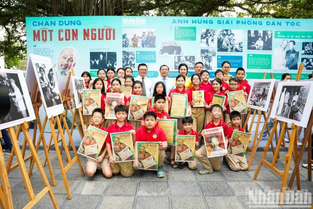 Les délégués posent pour une photo souvenir avec les élèves présents à l’exposition. Photo : nhandan.vn