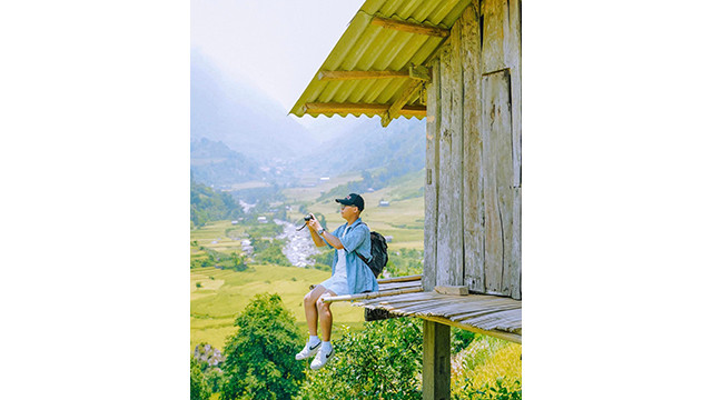 Assis en hauteur, ils admirent la beauté des champs. Photo : NGOC LAM