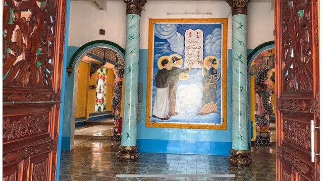 La peinture de « Tam Thanh Ky Thiên Nhân Hoa uoc » représente trois personnages considérés comme des saints de la religion caodaïste, écrivant un traité de paix entre Dieu et l'humanité. Photo : hanoimoi.vn La peinture de « Tam Thanh Ky Thiên Nhân Hoa uoc » représente trois personnages considérés comme des saints de la religion caodaïste, écrivant un traité de paix entre Dieu et l'humanité. Photo : hanoimoi.vn