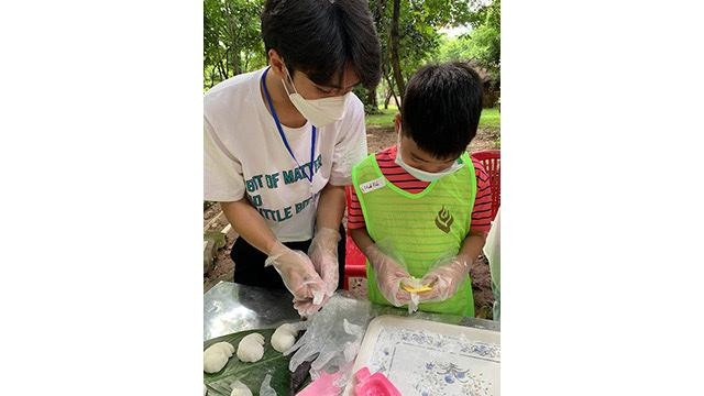 Un petit garçon confectionne un banh deo. Photo : Linh Vi/NDEL.