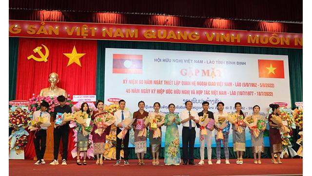 La remise des bourses d'études aux étudiants laos lors de la rencontre. Photo: binhdinh.gov.vn