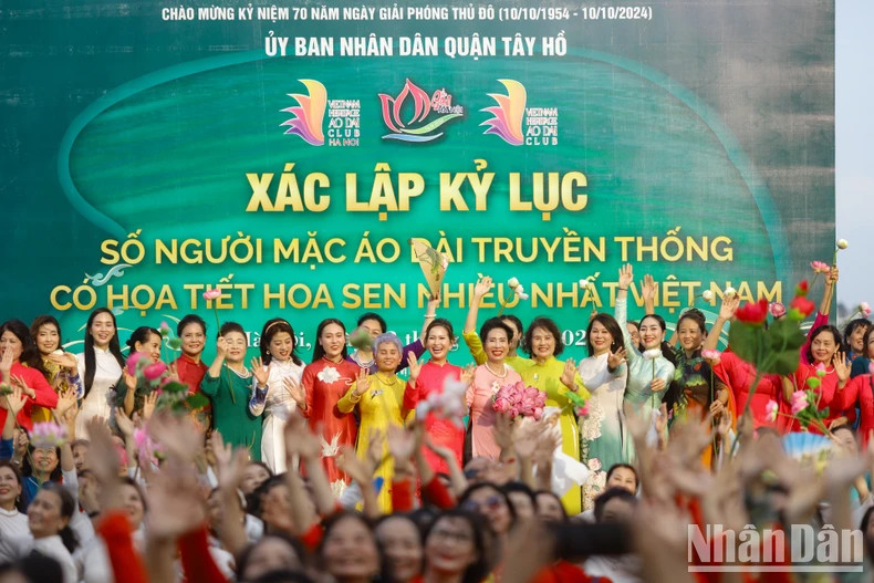 Le record : « Le plus grand nombre de personnes portant l'ao dài (tunique traditionnelle vietnamienne) avec des motifs de lotus au Vietnam ». Photo : nhandan.vn Le record : « Le plus grand nombre de personnes portant l'ao dài (tunique traditionnelle vietnamienne) avec des motifs de lotus au Vietnam ». Photo : nhandan.vn