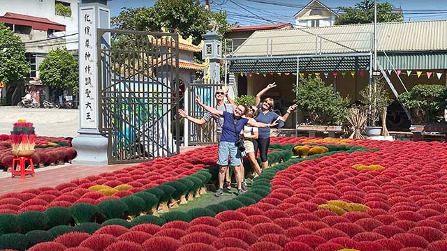 Les touristes étrangers sont fascinés par une carte du Vietnam créée avec des centaines de bouquets de bâtonnets d’encens colorés dans le village de Quang Phu Cau. Photo : Phuong Trang.