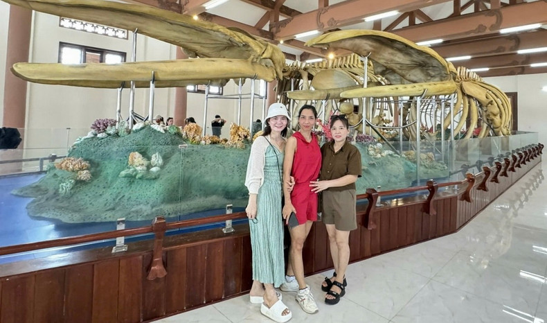 Des touristes prennent des photos de souvenirs avec deux squelettes de baleine. Photo : VOV.