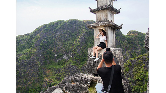 Des touristes prennent des photos dans la zone touristique de la cave de Hang Mua dans la province de Ninh Binh. Photo : VOV. Des touristes prennent des photos dans la zone touristique de la cave de Hang Mua dans la province de Ninh Binh. Photo : VOV.