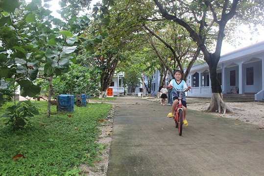 Les enfants de l'île font du vélo sous les arbres. Photo : baobacgiang.com.vn Les enfants de l'île font du vélo sous les arbres. Photo : baobacgiang.com.vn