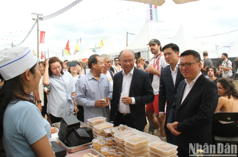 Le rédacteur en chef Lê Quôc Minh et l’ambassadeur Dinh Toan Thang visitent le stand du Laos. Photo: NDEL