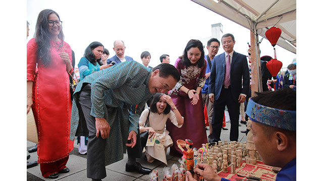 Le gouverneur de la préfecture de Kanagawa s’est arrêté au stand de fabrication des marionnettes et des « tò he » (figurines de pâtes de riz gluant colorées) du ministère de la Culture, des Sports et du Tourisme, et l’a beaucoup admiré. Photo : bvhttdl.gov.vn Le gouverneur de la préfecture de Kanagawa s’est arrêté au stand de fabrication des marionnettes et des « tò he » (figurines de pâtes de riz gluant colorées) du ministère de la Culture, des Sports et du Tourisme, et l’a beaucoup admiré. Photo : bvhttdl.gov.vn