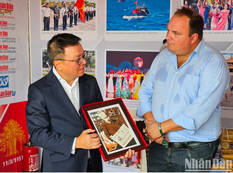 Le rédacteur en chef Lê Quôc Minh présente une photo intitulée « L’Oncle Hô lisant le journal Nhân Dân » au rédacteur en chef, Fabien Gay, et exprime son souhait que l’amitié entre les communistes français et vietnamiens ainsi que la coopération entre les deux journaux du Parti va se développer de plus en plus. Photo : NDEL