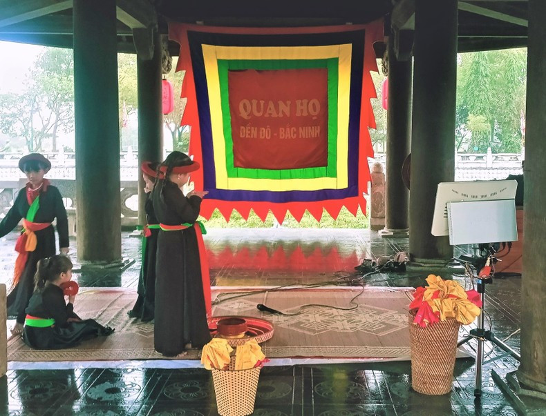 Des jeunes membres du Club du chant "Quan họ" du temple Dô à la maison communale sur un lac du temple Dô. Photo : NDEL.