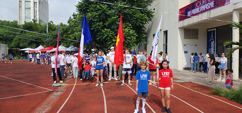 Un défilé marque l'arrivée de la flamme olympique, remise par le Comité Olympique National du Vietnam, créant un moment fort et symbolique de la journée. Photo : Minh Hanh.