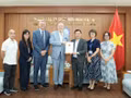 Nguyen Ngoc Hung remet à l’IESC le certificat d’enregistrement pour la création de son bureau de représentation au Vietnam. Photo : baothoidai.