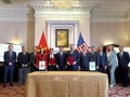 La cérémonie de signature d'un protocole d'accord entre des représentants vietnamiens et américains. Photo : VNA.