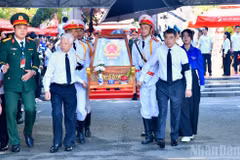 Le PM Le Minh Hung (à droite), l’ancien président Nguyen Minh Triet (à gauche) et d’autres délégués escortent les dépouilles des martyrs depuis le parc Le Thi Rieng. Photo : NDEL.