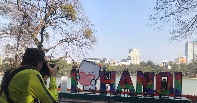Des touristes au lac de Hoan Kiem (Epée restituée). Photo : daidoanket.