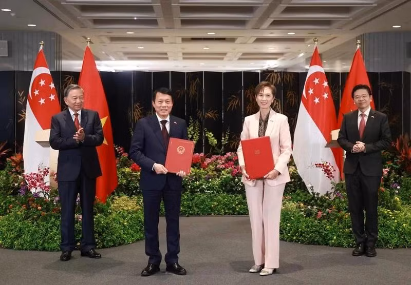 Le secrétaire général du Parti communiste du Vietnam (PCV), Tô Lâm (à gauche), et le Premier ministre singapourien, Lawrence Wong (à droite), assistent à l'échange d'un protocole d'accord sur la transformation numérique entre le ministère vietnamien de la Sécurité publique et le ministère singapourien du Développement numérique et de l'Information, le 12 mars. Photo : VNA. 