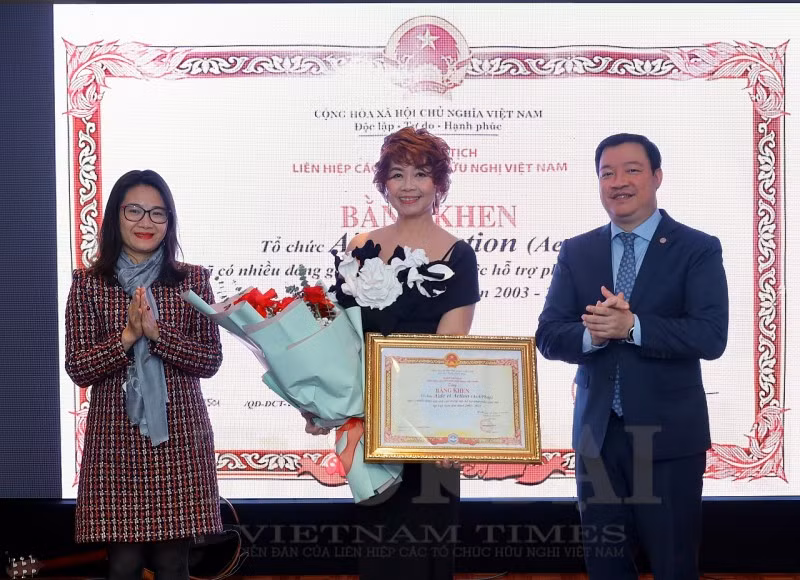Le vice-président de l'Union des organisations d'amitié du Vietnam, Nguyên Ngoc Hùng (1er à droite), remet un certificat de mérite à la directrice de l’AeA Vietnam, Nguyên Thi Tu. Photo: thoidai.com.