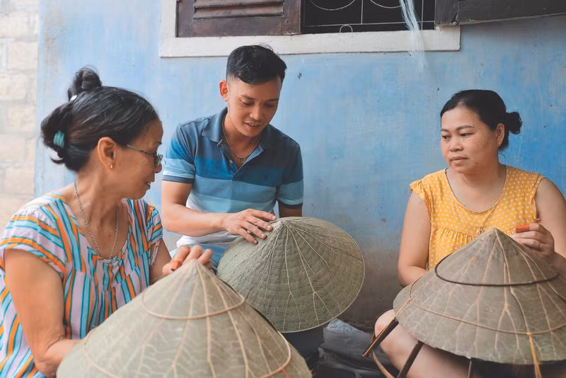 Nguyên Thanh Thao discute avec deux artisanes du village traditionnel de Đôc So.