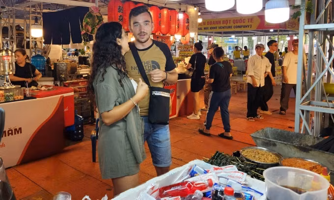 Maria et son petit ami cherchent des plats vietnamiens lors du festival le soir du 23 octobre. Photo : Bich Phuong. 