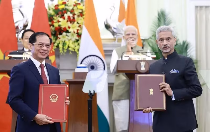 Les responsables des ministères des Affaires étrangères du Vietnam et de l’Inde s’échangent l'accord entre les deux gouvernements permettant aux proches des membres des missions diplomatiques et des consulats de travailler contre rémunération. Photo : VNA