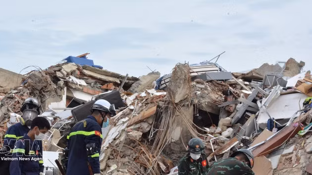 Les secouristes vietnamiens s'efforcent de chercher des victimes sous les décombres. Photo : VNA