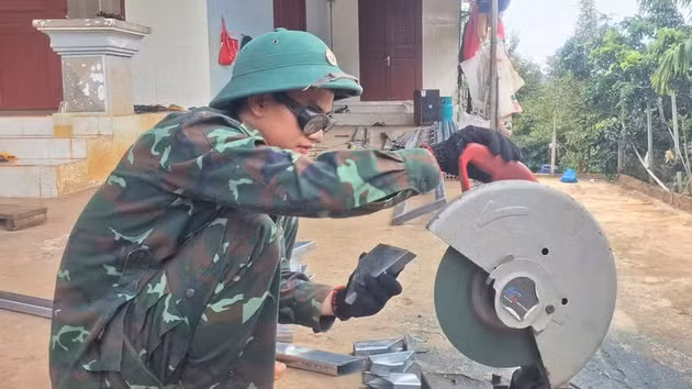 Un soldat de la compagnie 17 participent à la construction de la nouvelle maison de la famille de Mme Duong Thi Thanh. Photo : N.T.