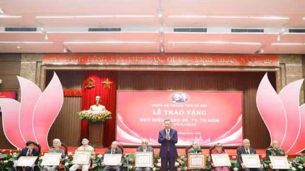Le secrétaire général du Parti et président To Lam remet des insignes commémoratifs de 80 ans d'adhésion au Parti à 19 membres. Photo : VNA. 