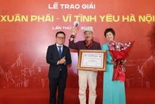 Lê Quôc Minh (à gauche), membre du Comité central du Parti, chef adjoint de la Commission de la sensibilisation, de l'éducation et de la mobilisation de masse du Comité central du Parti et président de l'Association des journalistes vietnamiens, et Vu Viêt Trang (à droite), directrice générale de l'Agence vietnamienne d’information, remettent le Grand prix au musicien Trân Tiên. Photo : NDEL
