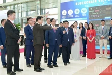 Le Premier ministre Pham Minh Chinh et des responsables gouvernementaux visitent le stand du Réseau de services multichaîne Blockchain Vietnam. Photo : HD.